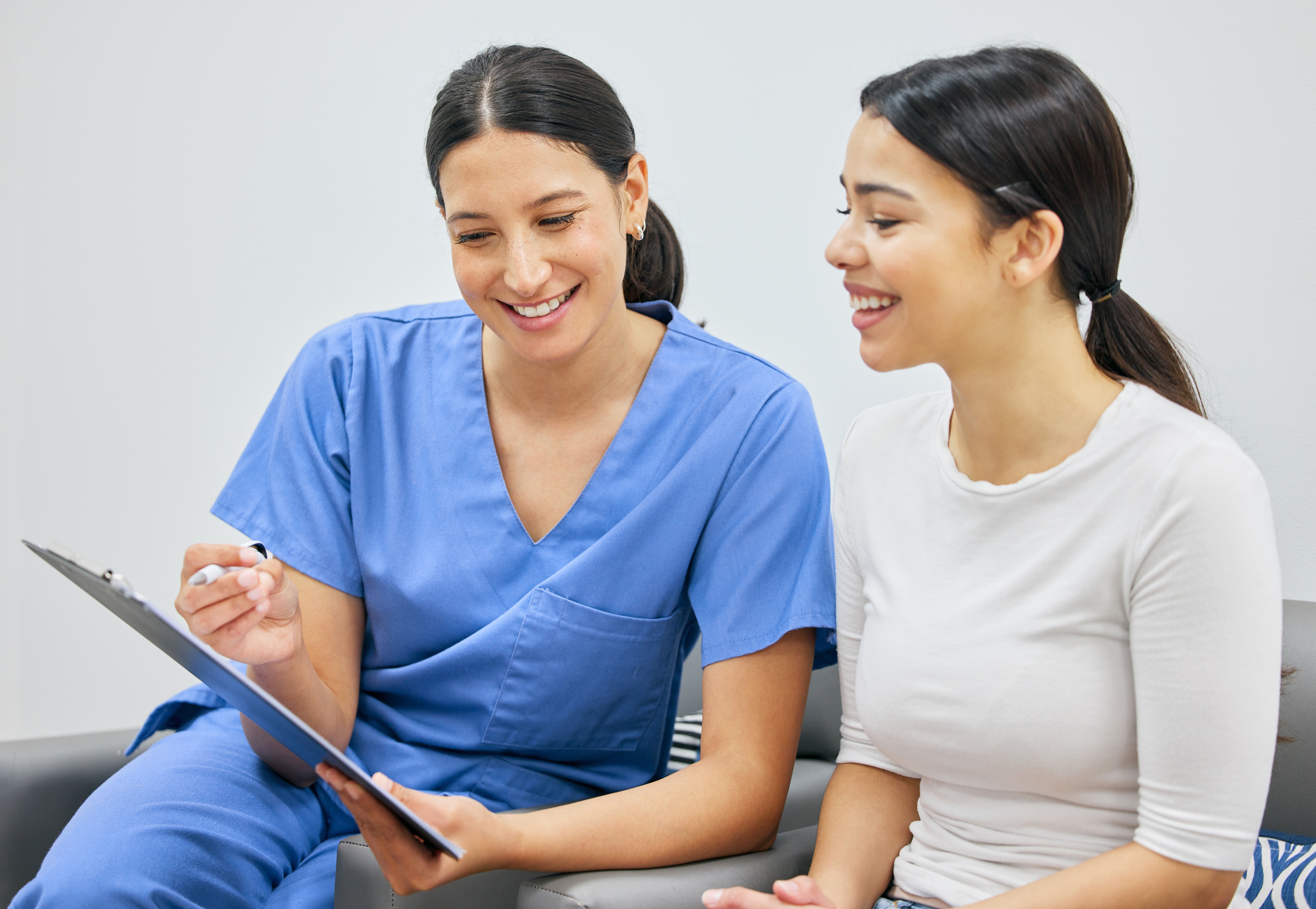 woman nurse practicing healthcare compliance with a clipboard and a happy patient woman