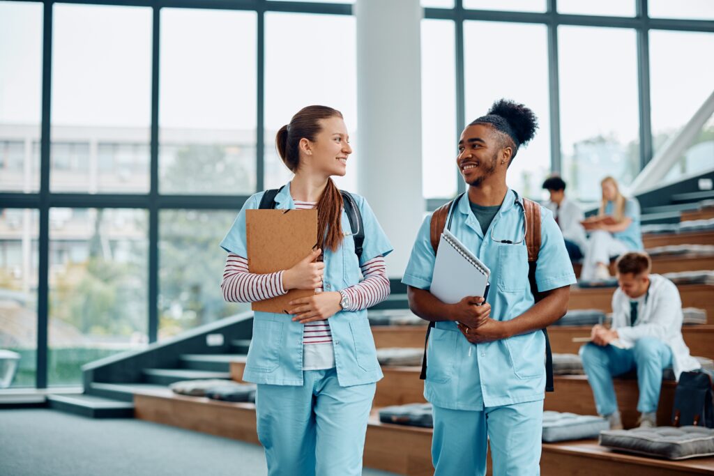 two nurses with clipboards walking in a hospital